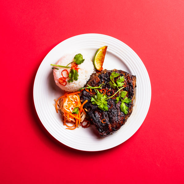 Vietnamese style Marinated Heritage Porterhouse Pork Chop with rice, pickles, and lime